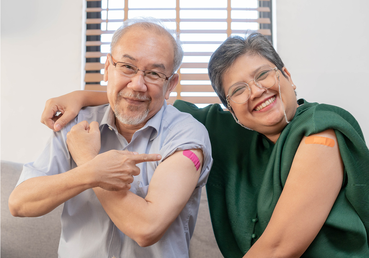 Asian couple showing off their band aids from getting vaccinated