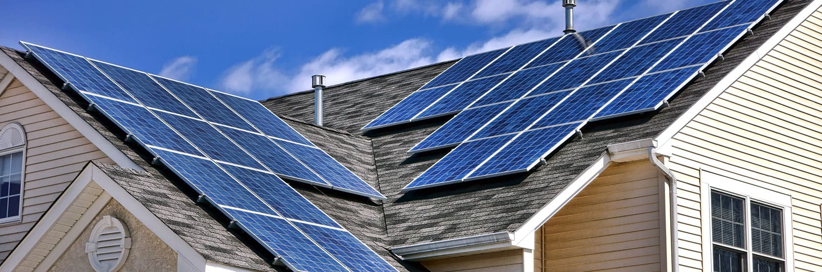 Men technicians in helmets installing solar module with help of hex key outdoors.