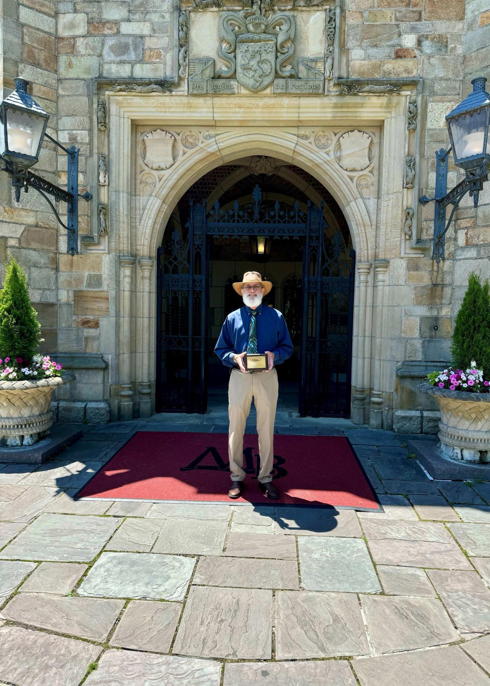Oakland County WRC Jim Nash stands outside Meadow Brook Hall holding his Lifetime Contribution Award from the American Soiceity of Public Administration - Detroit