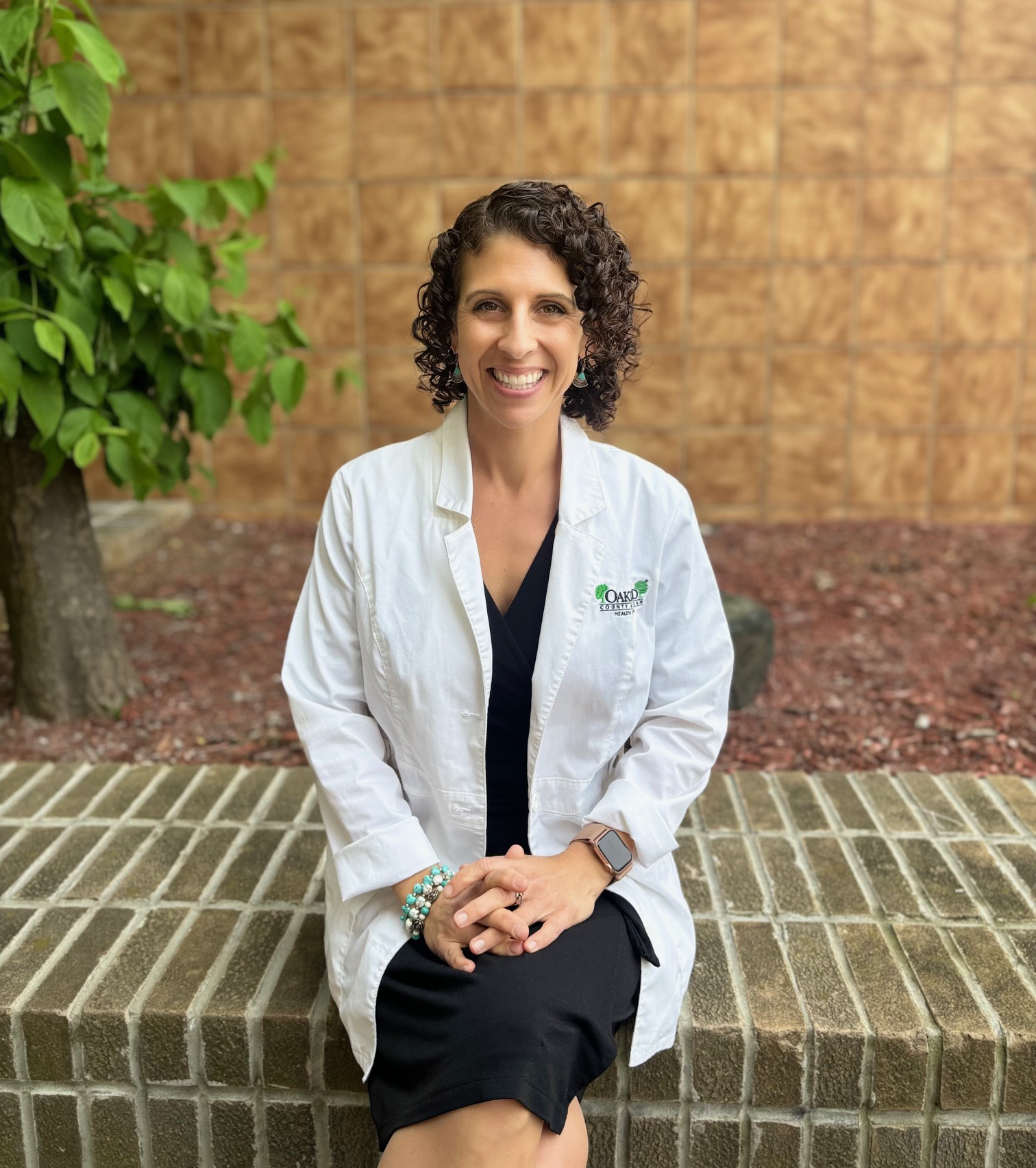 Woman wearing a labcoat sitting