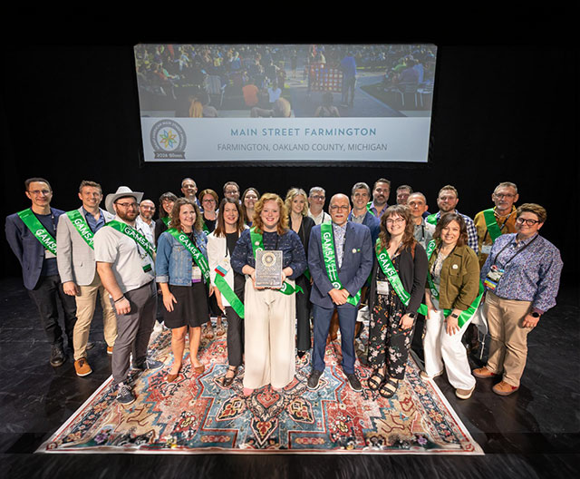 Group of people wearing sashes on a stage.