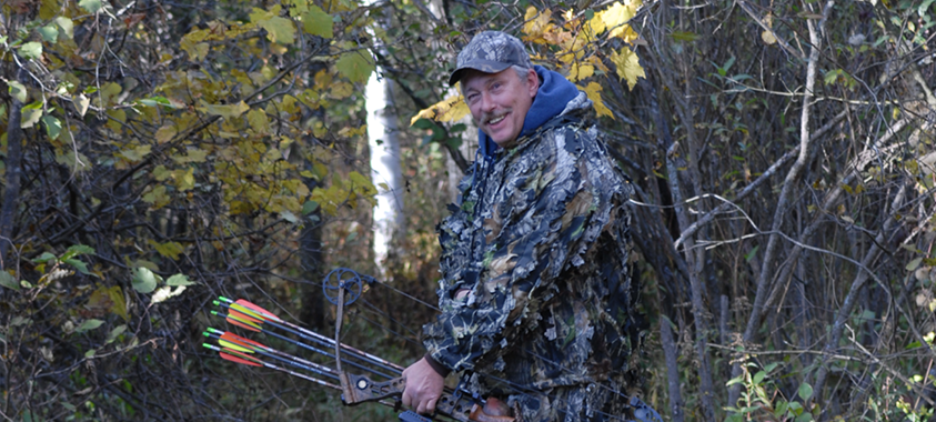 Man in camo with bow and arrows Man in camo with bow and arrows in the woods